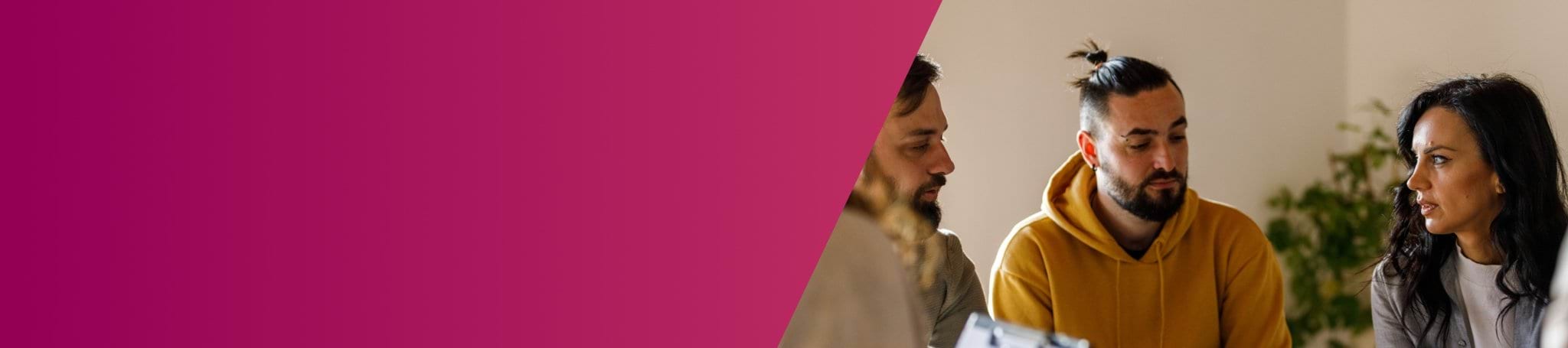 two men and a woman talking in a room