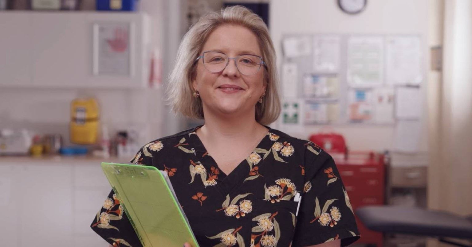 Nurse holding a clip board standing inside one of Victoria's Urgent Care Clinics